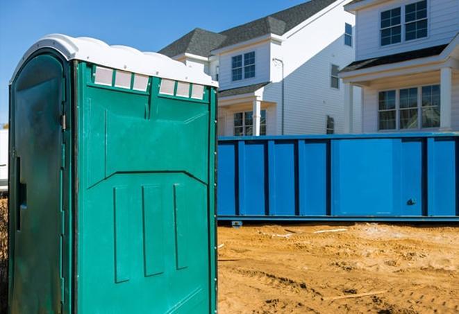 a row of porta potties on a bustling construction site